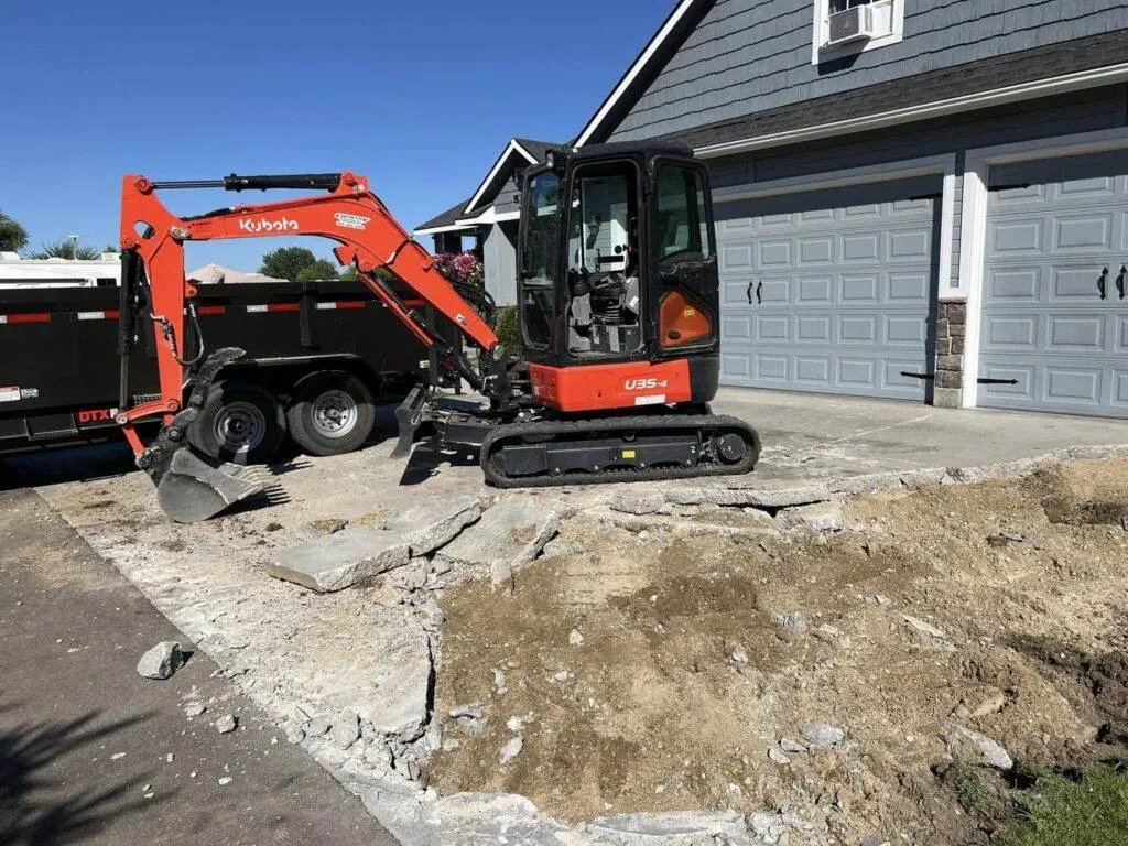 Risser Dirt Works Excavator Removing a Driveway to Prep for a New one